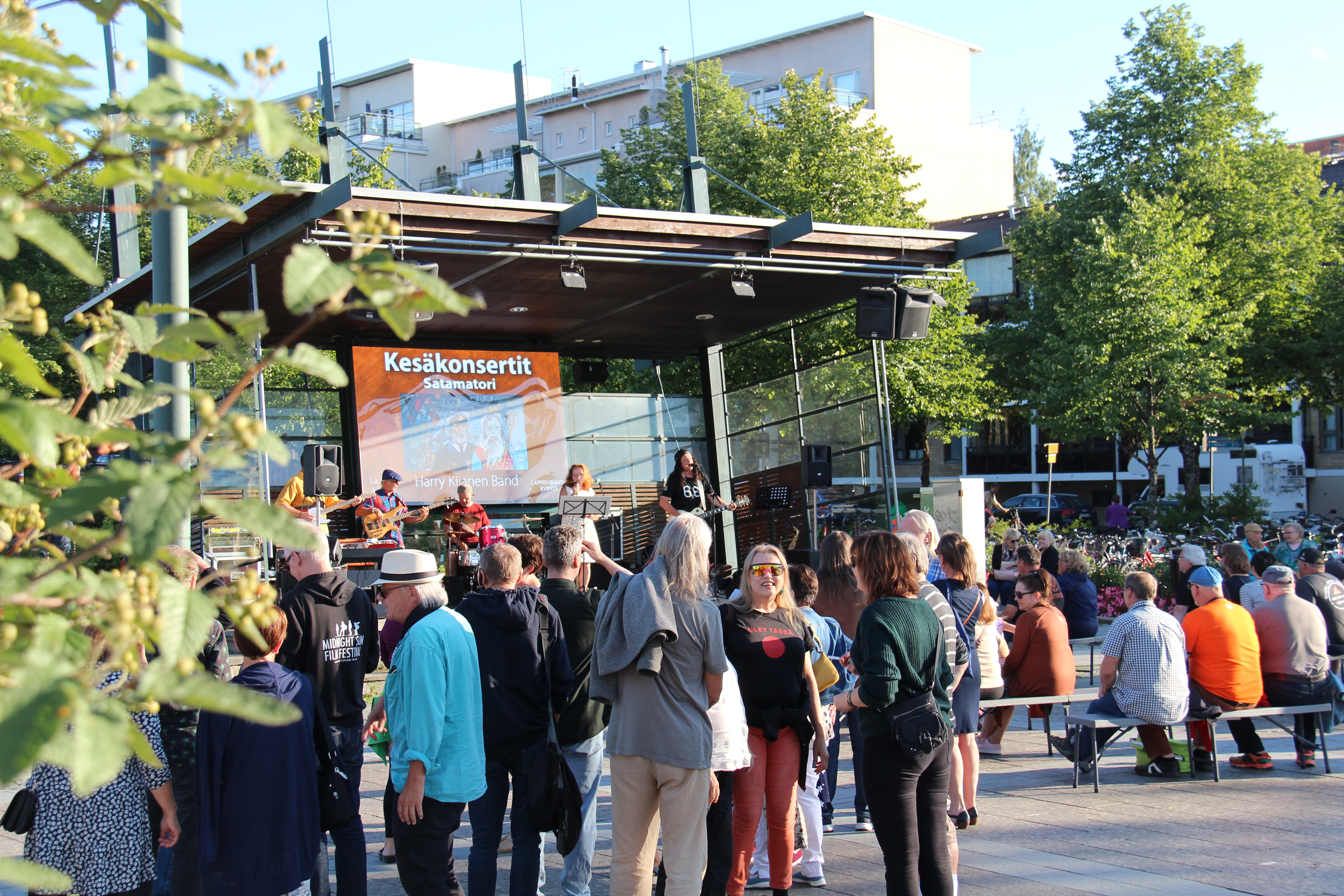 Ihmisiä seuraamassa kesäkonserttia Lappeenrannan Satamatorilla.